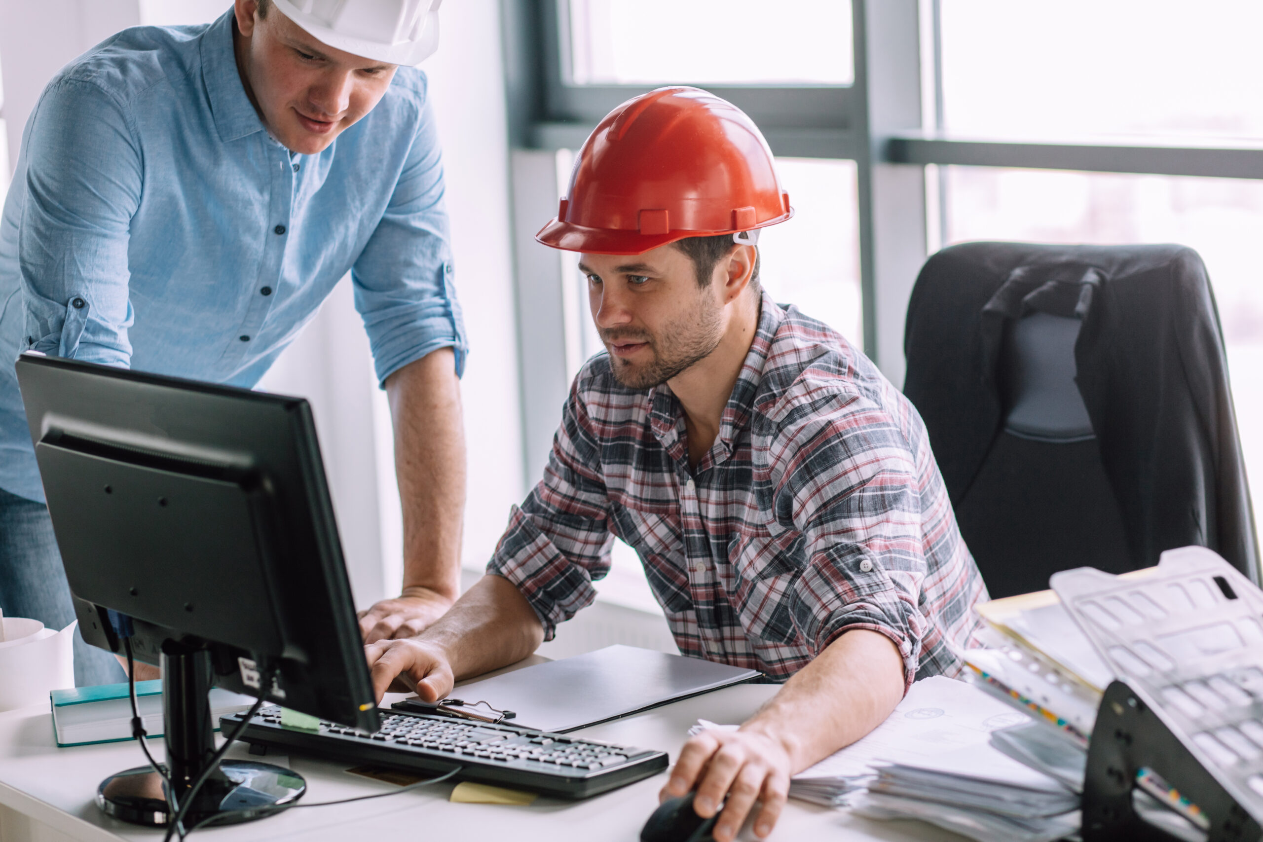 young ambitious constructor with his partner are doing the model of building on the computer. engineer is good at computers